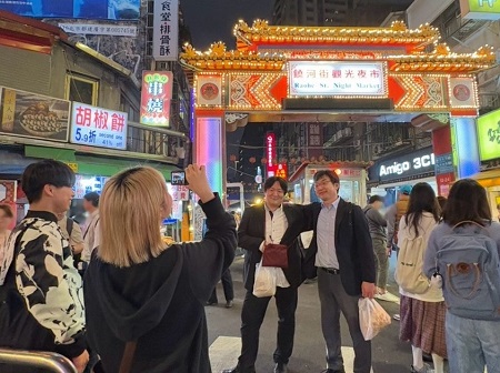 饒河街觀光夜市(台北)にて、成城大学の教員2名が学生に促されて記念撮影。学生たちと一緒に最後の夜を楽しみました。学生と教員の垣根が低いのも、社会イノベーション学部の特徴の一つです。