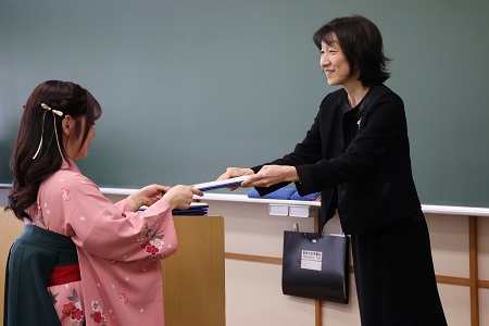 ゼミナール担当教員から学位記を受け取る卒業生